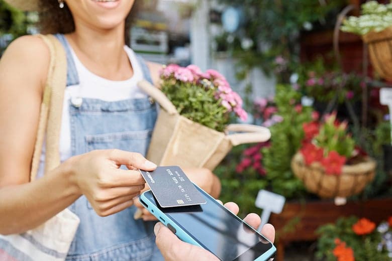 Woman using credit card to pay for flowers