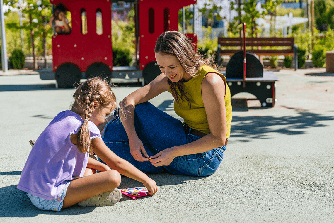 Woman and child playing together at a playground