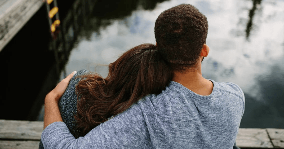 Couple sitting together by the water