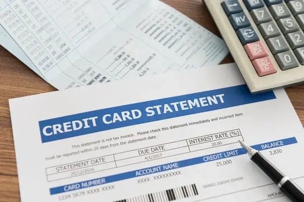 Credit card statement and calculator used to review account activity