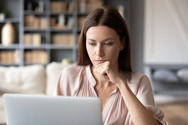 Person reviewing tax refund check and credit card statements at a desk