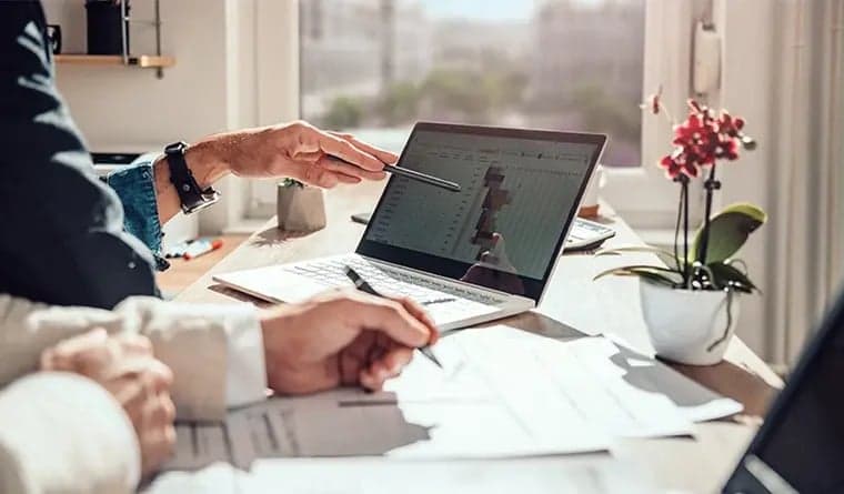 Financial advisor reviewing a plan on a laptop with a client