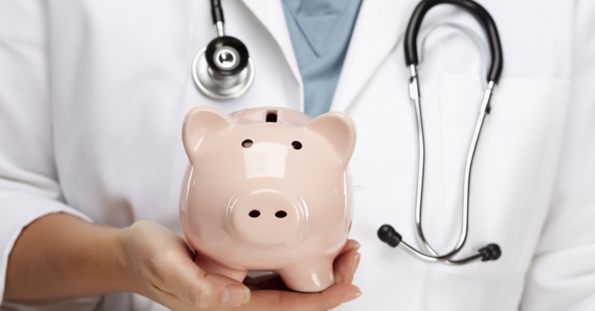 Doctor with stethoscope holding piggy bank